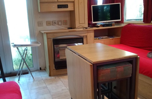 Couret House | Mobile home on a quiet wooded lot with a barbecue and outdoor table.